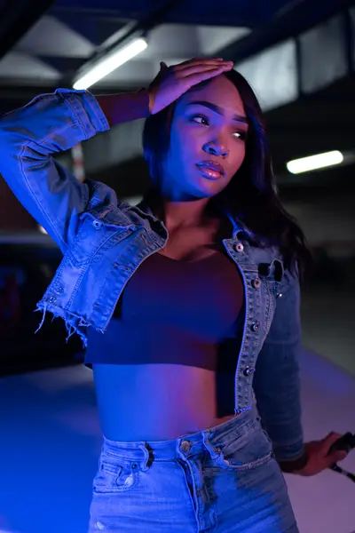 Book de modelo con chaqueta vaquera e iluminación azul en estudio