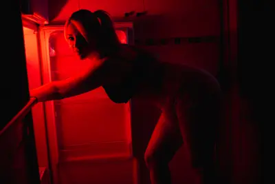 Sesión privada con iluminación de neón rojo, tratada con total discreción